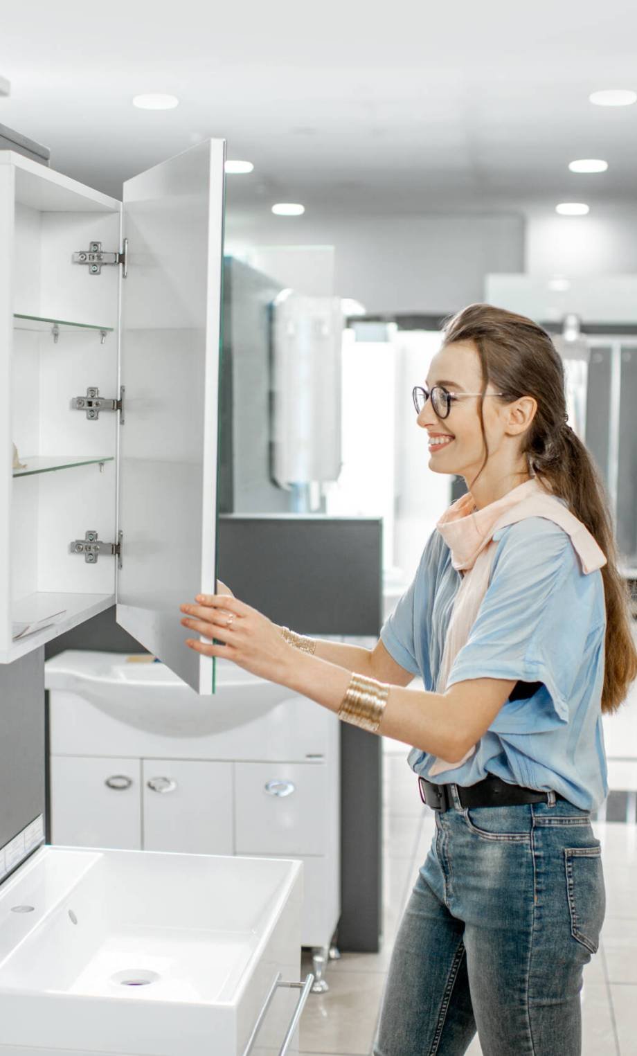 Young couple choosing new bathroom furniture at the plumbing shop with lots of sanitary goods